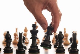 A hand moving a chess piece during a game