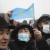 Demonstrators, one of which holds a national flag, gather near a police line during a protest in Almaty, Kazakhstan, Wednesday, Jan. 5, 2022. Demonstrators denouncing the doubling of prices for liquefied gas have clashed with police in Kazakhstan's largest city and held protests in about a dozen other cities in the country. (AP Photo/Vladimir Tretyakov)