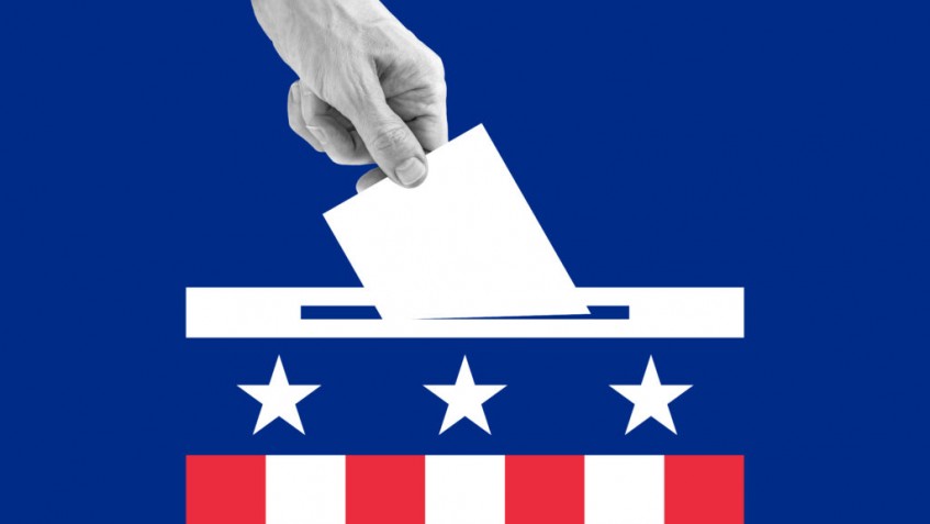 The human hand drops the ballot into the box.