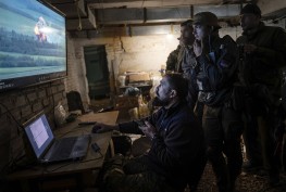 -- EMBARGO: NO ELECTRONIC DISTRIBUTION, WEB POSTING OR STREET SALES BEFORE 12:01 A.M. ET ON TUESDAY, NOV. 15, 2022. NO EXCEPTIONS FOR ANY REASONS -- FILE — A drone operator shares footage of an attack against a Russian position with fellow soldiers of the Ukrainian army’s Carpathian Sich Battalion at an underground base in the Kharkiv region of Ukraine, May 11, 2022. Though the battle for Ukraine remains largely a grinding artillery war, new advances in technology and training there are being closely monitored for the ways they are starting to shape combat. (Lynsey Addario/The New York Times) -- NO SALES --