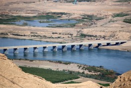 A bridge spans the Tigris river near the Makhoul dam site, in northern Iraq's Salaheddine province, on November 1, 2022. - In a country threatened by climate change, apparent in three consecutive years of drought ,authorities defend Maqhoul dam project, which will allow, among other things, water to be stockpiled against shortages. However, NGOs decry the repurcussions on around 30 villages ,home to nearly 120,000 people, and the threats to biodiversity at several archaeological sites. (Photo by Sabah ARAR / AFP)